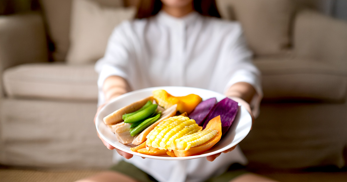 A women holding a plate meal with fiber foods.