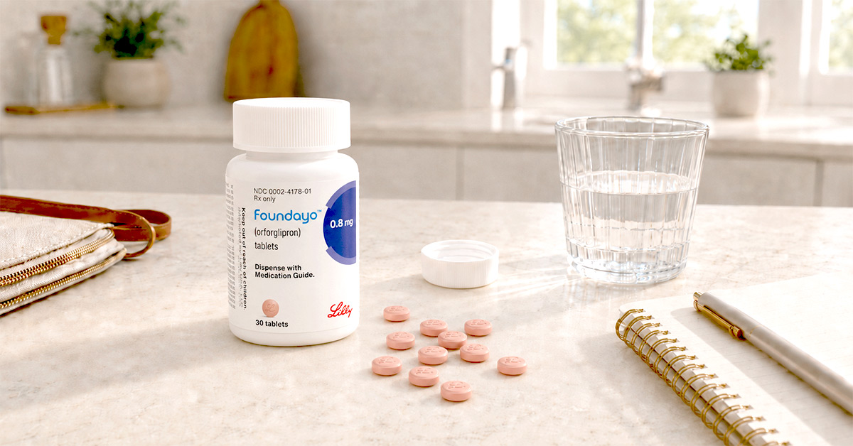 Foundayo weight loss pill bottle with pink tablets, water glass, and notebook on a bright kitchen counter.