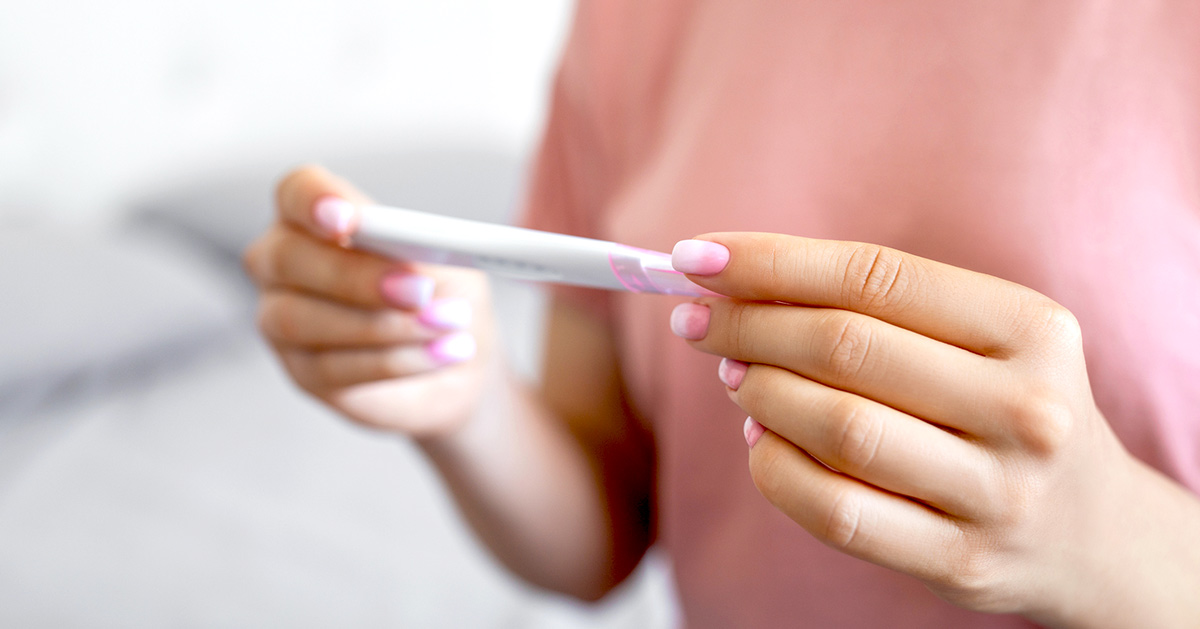 A woman holding a pregnancy test in her hands