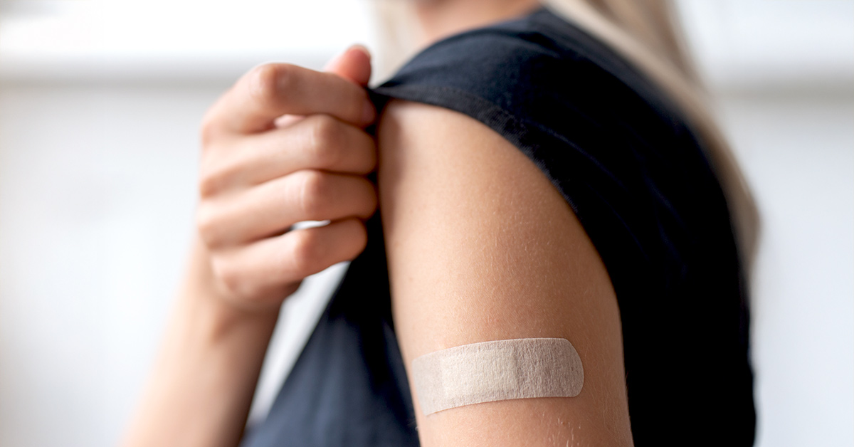 Person with bandage on upper arm after GLP-1 injection site reaction.