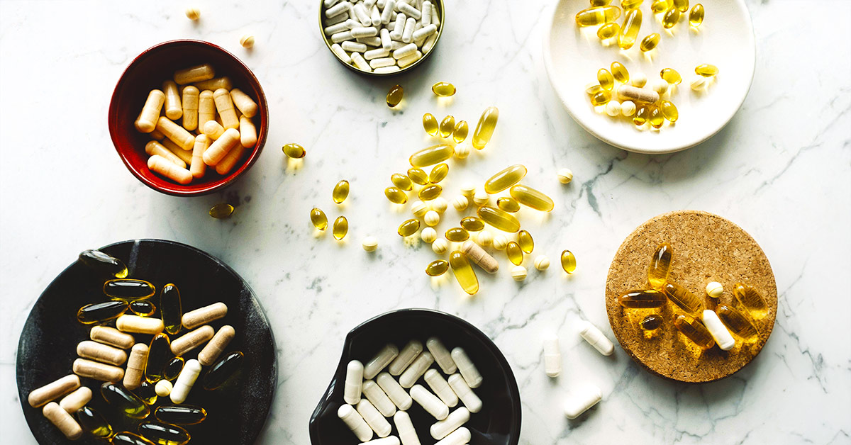 Probiotic supplements placed on a white marble surface.