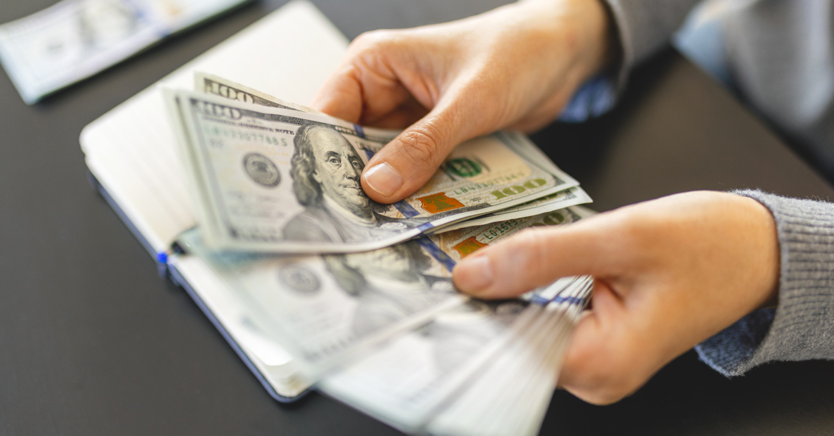 Woman holding 100 dollar bills 