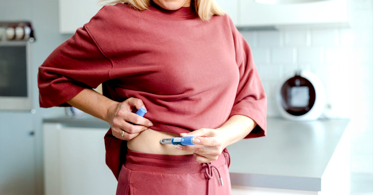 A women injecting ozempic in right side of stomach