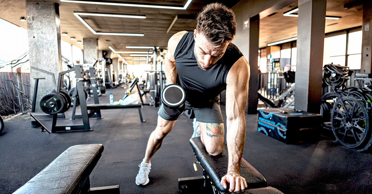 Man lifting weight on a bench at a gym